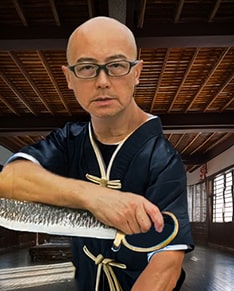 Photo of Sifu Calvin Chiu holding Wing Chun swords
