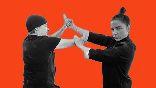 Sifu Kendra Mahon Kung Fu expert demonstrates pak sao with punch defense with a partner in wing chun