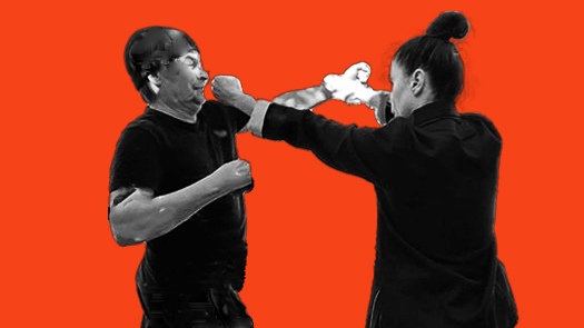 Sifu Kendra Mahon Kung Fu expert demonstrates bil sao with punch defense in wing chun with a partner