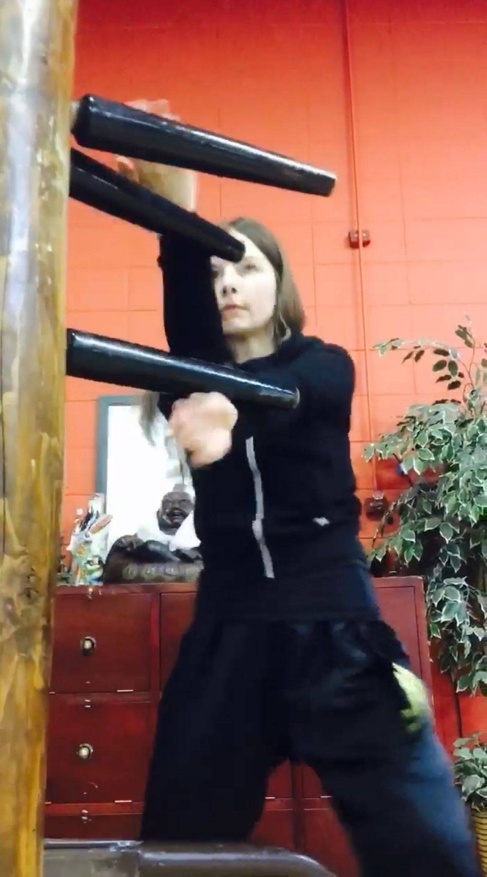 Female training on wooden dummy in kwoon